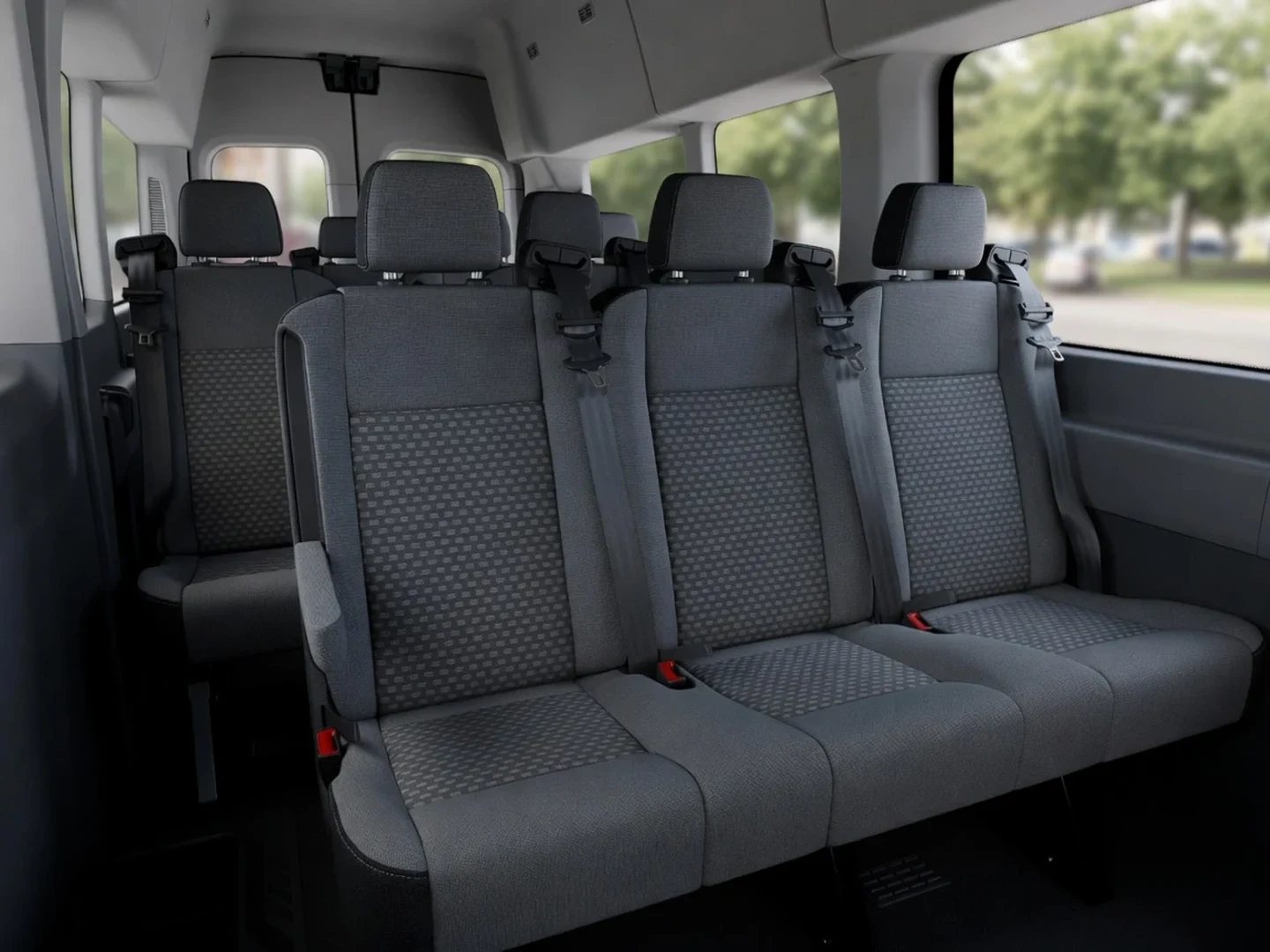 Ford Transit passenger van interior with gray cloth seats and seatbelts