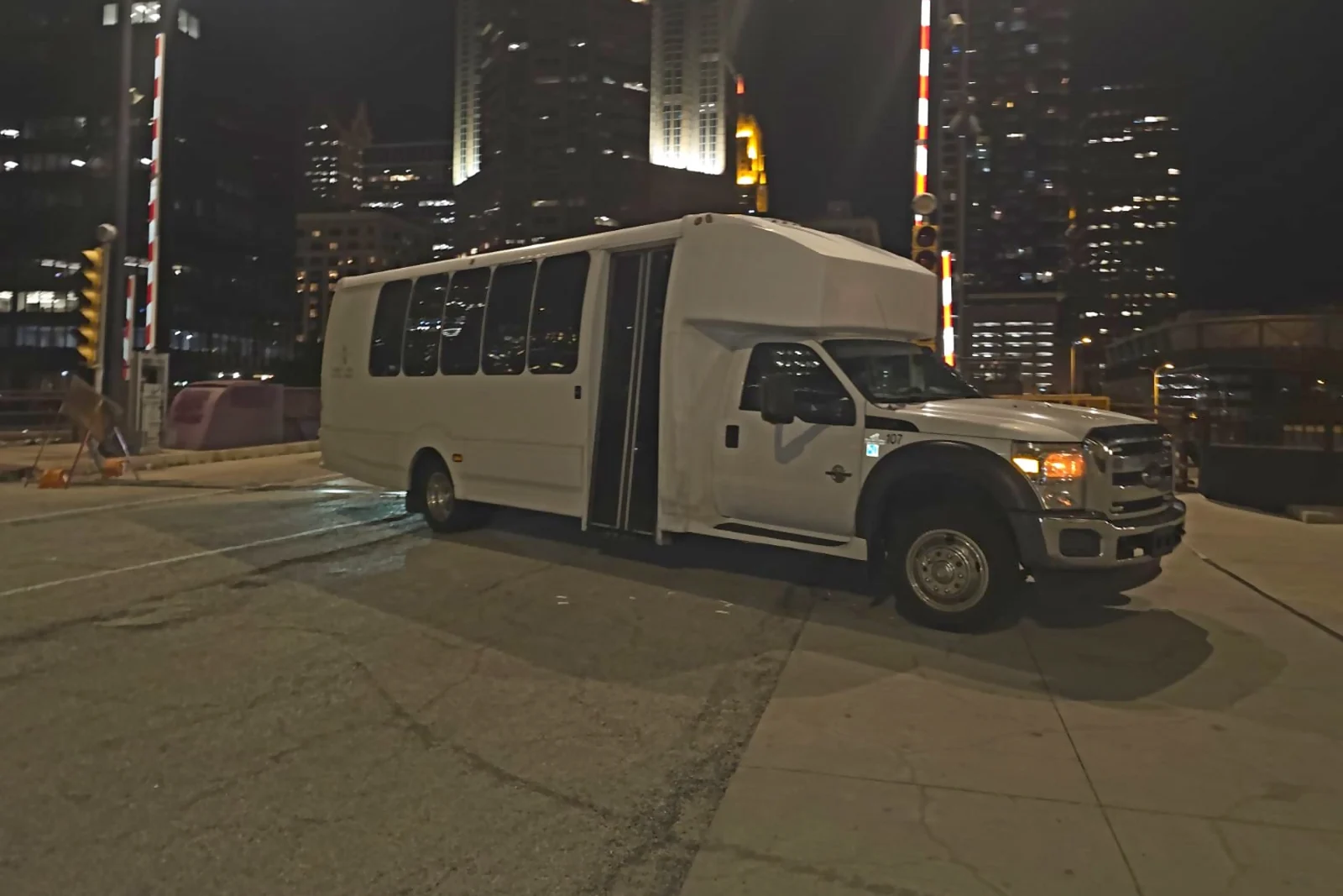 White 26-passenger mini bus downtown Chicago at night
