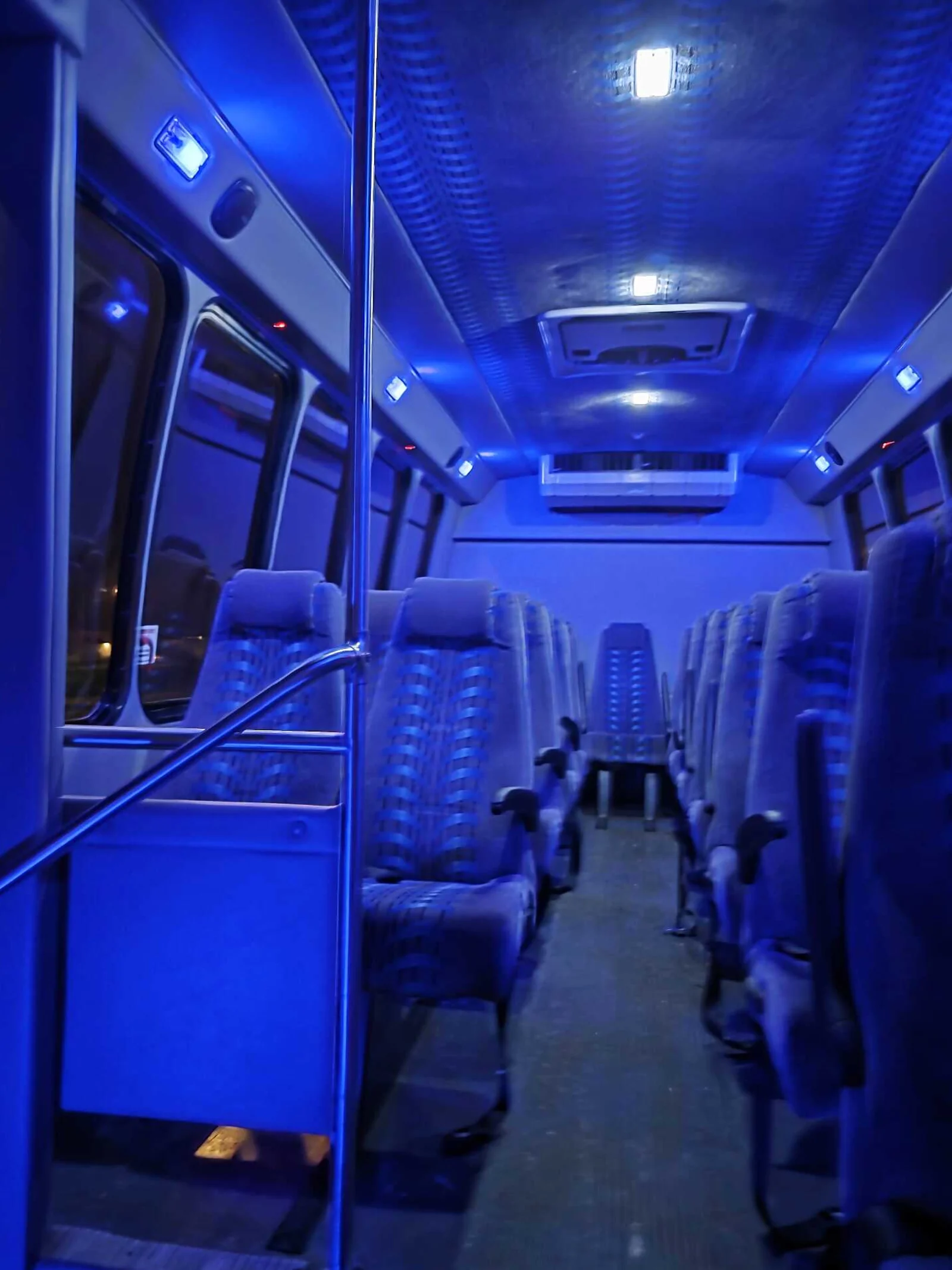 Mini bus interior with blue LED lighting and forward-facing seats
