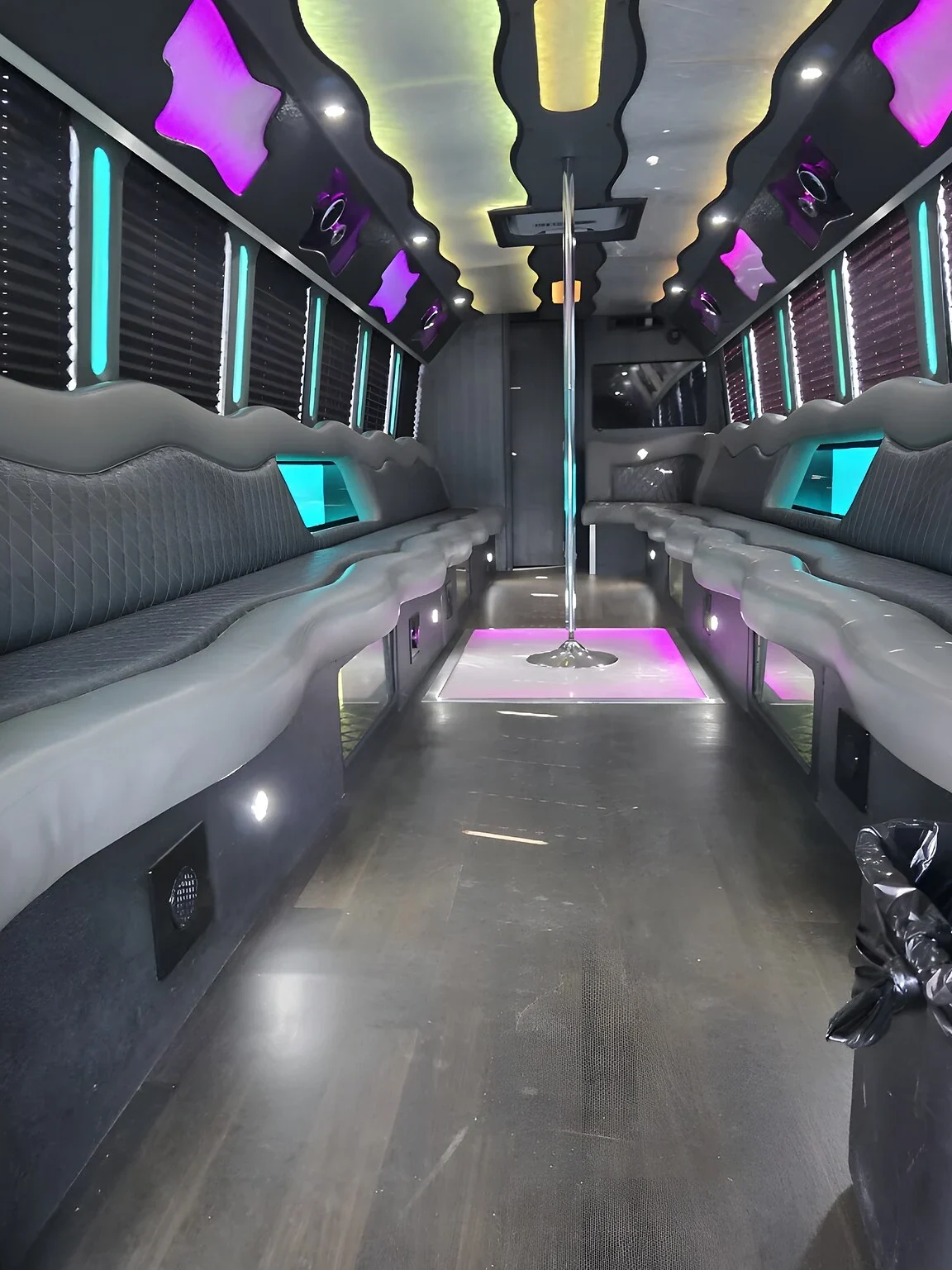 Party bus interior with wraparound seating under purple LED lighting