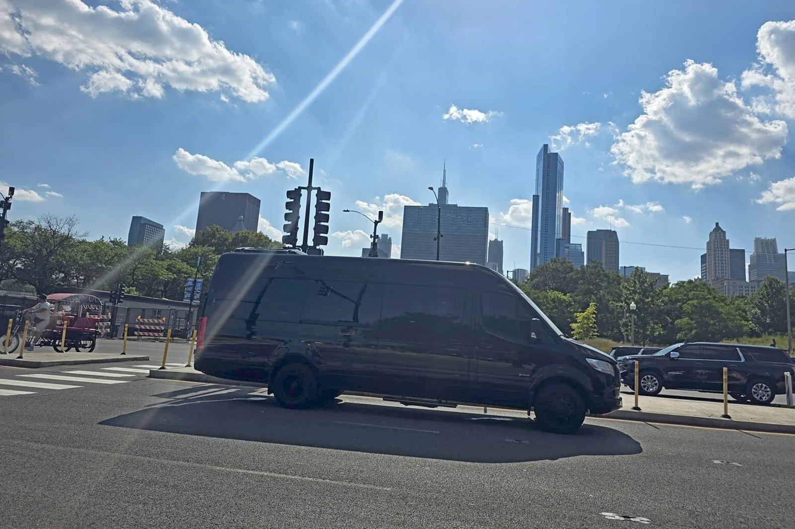 Black Mercedes Sprinter limo parked against the Chicago skyline
